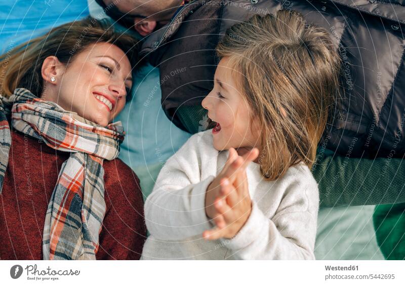 Glückliches Mädchen mit ihrer Familie auf der Decke klatscht in die Hände liegen liegend liegt entspannt entspanntheit relaxt glücklich glücklich sein
