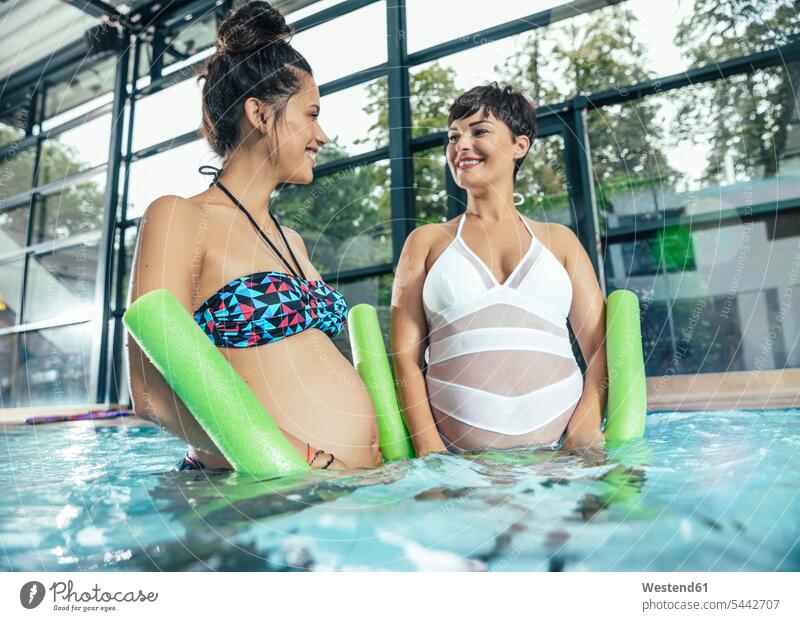 Zwei schwangere Frauen machen Wassergymnastik im Hallenbad Schwangere Schwimmbad Schwimmbaeder Schwimmbäder Hallenbäder Hallenbaeder Aqua Aerobic weiblich