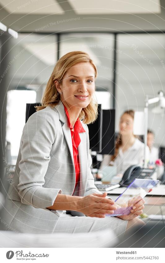 Porträt einer lächelnden Geschäftsfrau am Schreibtisch im Büro mit futuristischem Tablett Geschäftsfrauen Businesswomen Businessfrauen Businesswoman Office