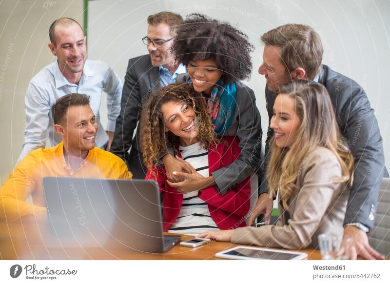 Kollegen im Sitzungssaal teilen sich einen Laptop Büro Office Büros Arbeitskollegen lächeln Notebook Laptops Notebooks Konferenzraum Konferenzraeume