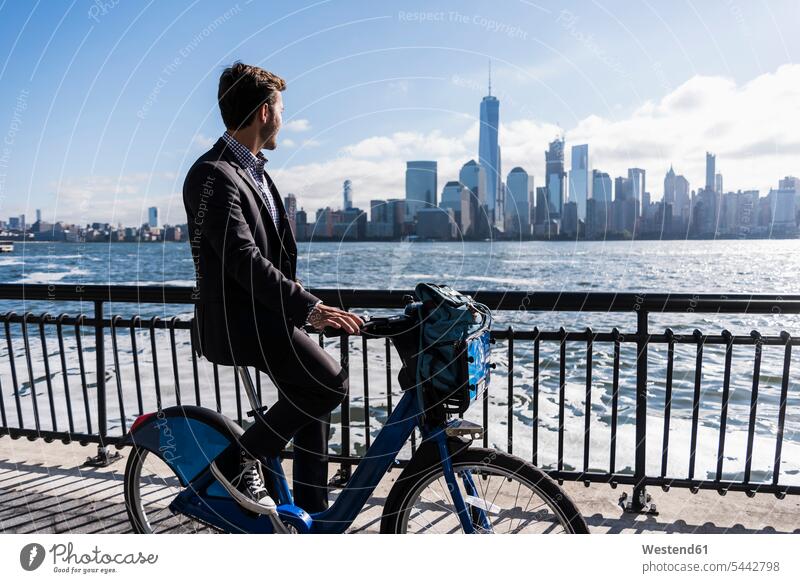 USA, Mann auf dem Fahrrad am Hafen von New Jersey mit Blick auf Manhattan Bikes Fahrräder Räder Rad Männer männlich fahren fahrend fahrender fahrendes