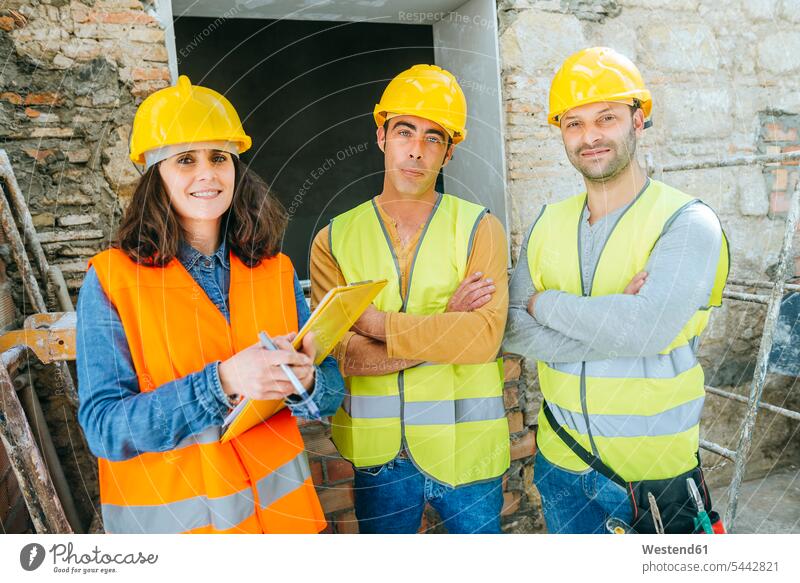 Frau mit zwei Bauarbeitern auf der Baustelle Kollegen Arbeitskollegen Baustellen Konstruktion konstruieren bauen Baugewerbe Handwerker Handwerksberuf
