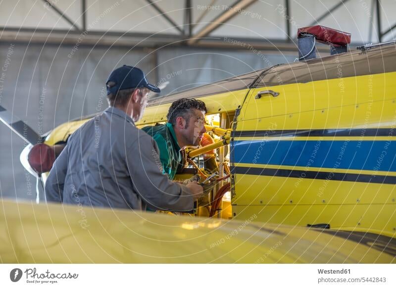 Mechaniker im Hangar bei der Reparatur von Leichtflugzeugen Flugzeug Flieger Flugzeuge Monteur Motor Motoren reparieren arbeiten Arbeit Verkehrswesen