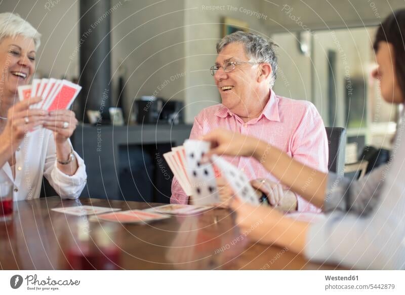 Älteres Ehepaar spielt mit der Tochter zu Hause Karten spielen Zuhause daheim Töchter Senior ältere Männer älterer Mann Senioren Paar Pärchen Paare