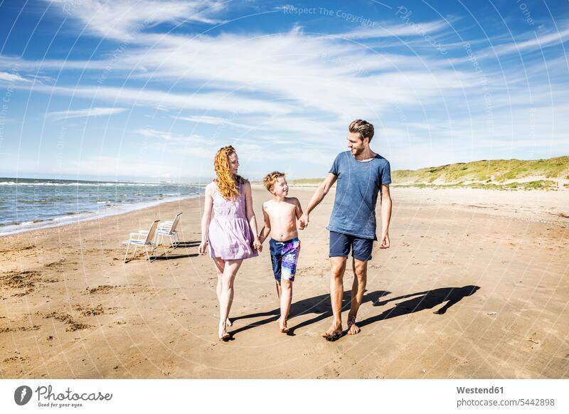Niederlande, Zandvoort, glückliche Familie beim Strandspaziergang Familien Beach Straende Strände Beaches lächeln Spaß Spass Späße spassig Spässe spaßig Glück