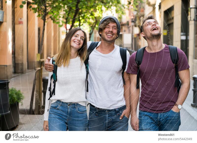 Glückliche Freunde beim Spaziergang in der Stadt gehen gehend geht lachen glücklich glücklich sein glücklichsein Freundschaft Kameradschaft positiv Emotion