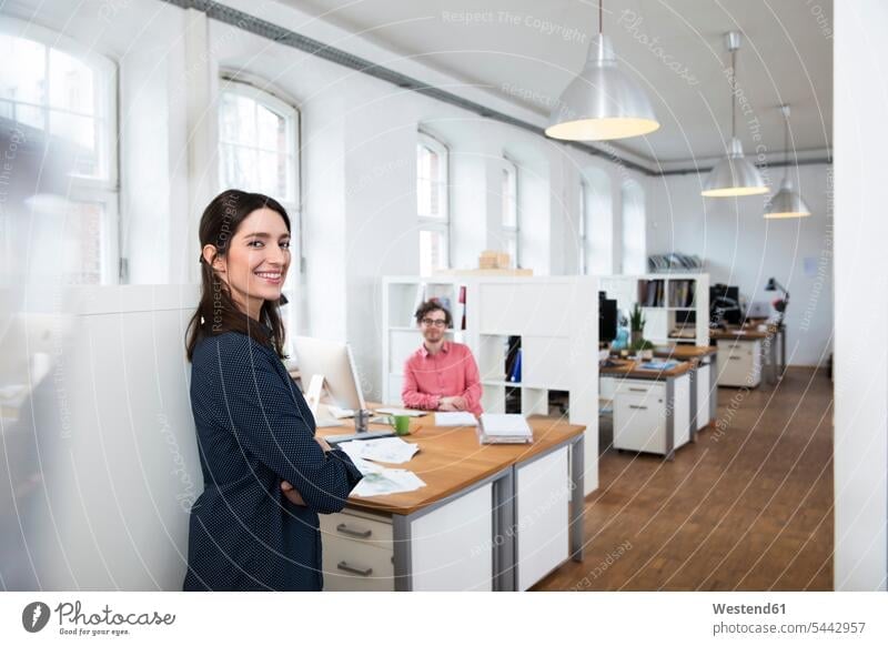 Porträt einer lächelnden Frau und eines lächelnden Mannes im Amt Büro Office Büros Arbeitsplatz Arbeitsstätte Arbeitstelle Kollegen Arbeitskollegen Business