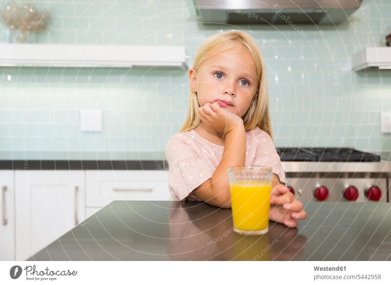 Porträt eines nachdenklichen Mädchens in der Küche mit einem Glas Orangensaft Portrait Porträts Portraits Saft Saefte Säfte Apfelsinensaft O-Saft Küchen