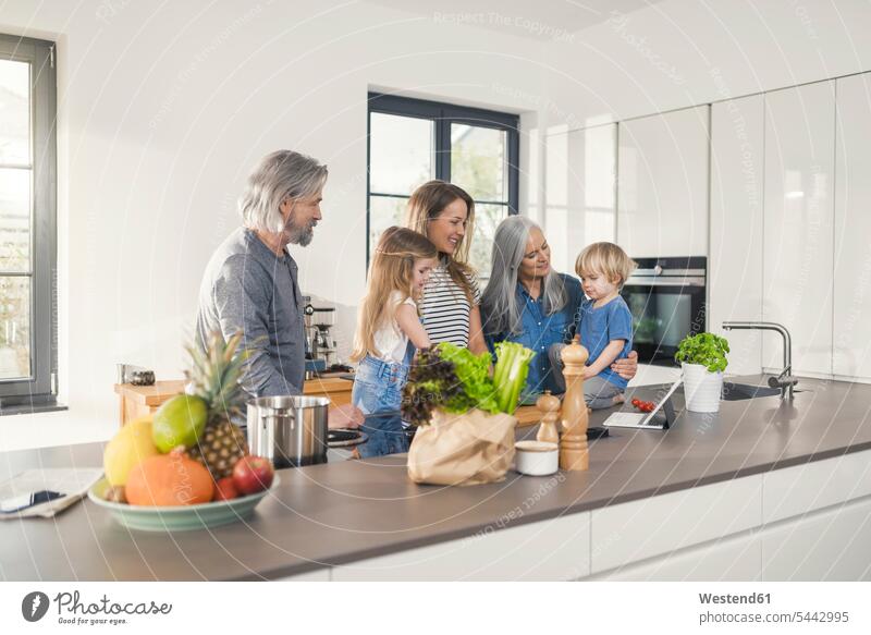 Großeltern mit Enkelkindern und ihre Mutter stehen in der Küche Küchen Gemeinsam Zusammen Miteinander glücklich Glück glücklich sein glücklichsein Familie