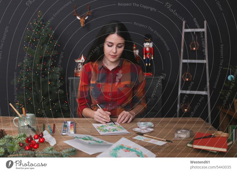 Junge Frau malt Weihnachtskarte mit Aquarellfarben weiblich Frauen malen Weihnachtskarten Erwachsener erwachsen Mensch Menschen Leute People Personen Karte