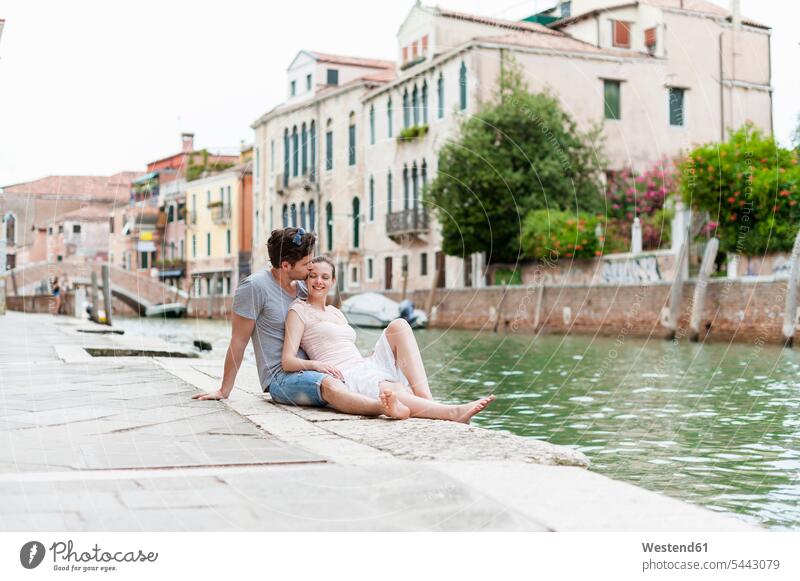 Italien, Venedig, verliebtes Paar entspannt sich am Kanal Pärchen Paare Partnerschaft Mensch Menschen Leute People Personen lächeln glücklich Glück