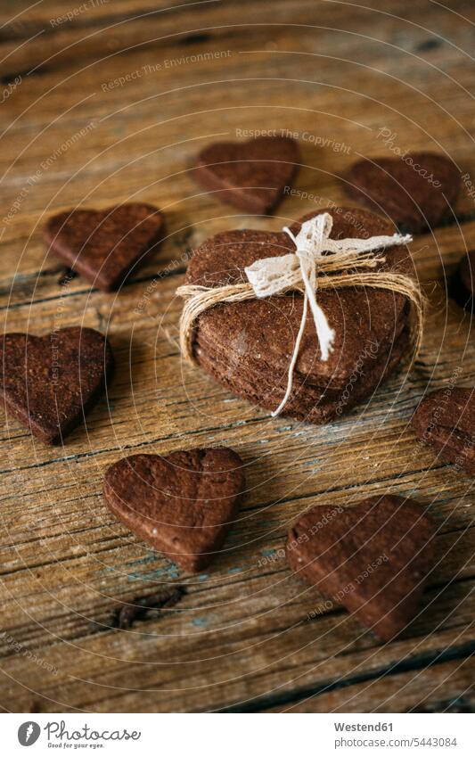 Herzförmige Schokoladen-Mürbekekse auf Holz Food and Drink Lebensmittel Essen und Trinken Nahrungsmittel Herzform Herzformen Herzen Schokoladenkeks