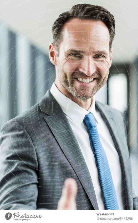 Porträt eines lächelnden Geschäftsmannes beim Händeschütteln Portrait Porträts Portraits Businessmann Businessmänner Geschäftsmänner Geschäftsleute