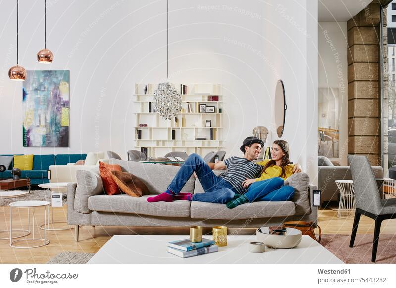 Ehepaar in modernem Möbelgeschäft testet Couch, ist glücklich Mobiliar Einrichtungsgegenstand Einrichtungsgegenstände hip trendy Paar Pärchen Paare