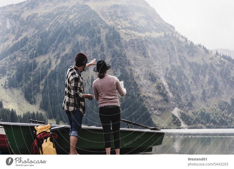 Österreich, Tirol, Alpen, Paar mit Karte am Bergsee stehend steht See Seen Pärchen Paare Partnerschaft Gewässer Wasser Mensch Menschen Leute People Personen