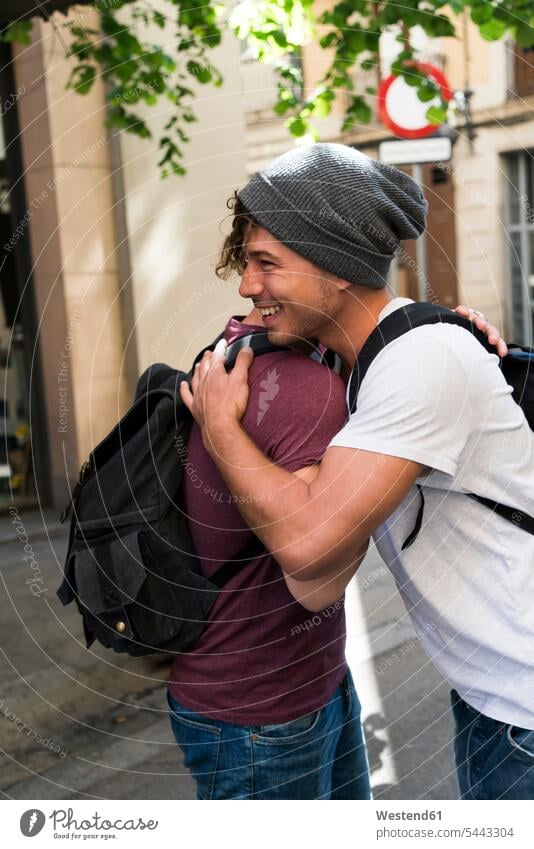 Zwei junge Männer umarmen sich in der Stadt Freunde Umarmung Umarmungen Arm umlegen lächeln glücklich Glück glücklich sein glücklichsein Freundschaft