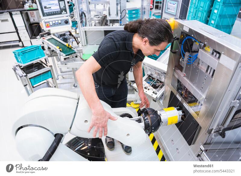 Mann mit Montageroboter in der Fabrik Roboter Männer männlich Fabriken arbeiten Arbeit Erwachsener erwachsen Mensch Menschen Leute People Personen Mittelstand