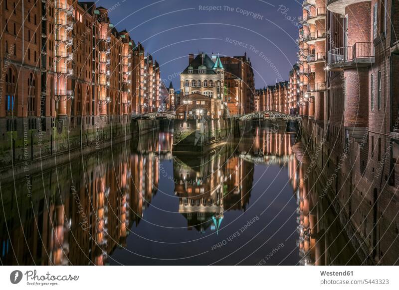 Deutschland, Hamburg, Speicherstadt, beleuchtete Altbauten mit Elbphilharmonie im Hintergrund Wolke Wolken Abendlicht abendliches Licht Wasserspiegelung