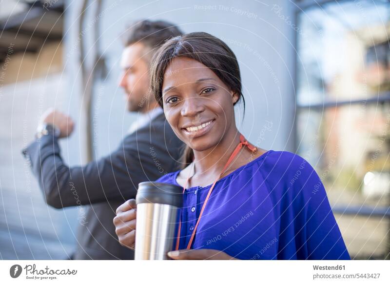 Porträt einer lächelnden Geschäftsfrau mit Kaffeetasse und eines Geschäftsmannes im Hintergrund Geschäftsfrauen Businesswomen Businessfrauen Businesswoman