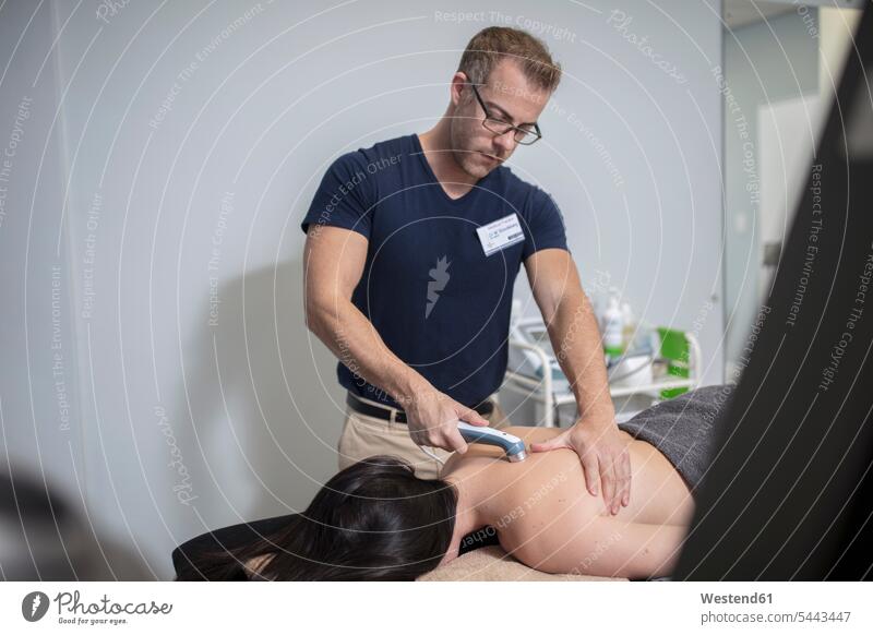 Physio-Massage des Rückens einer Frau mit einem Gerät Behandlung Behandlungen Massagen massieren Patientin Kranke Patientinnen Praxis Medizin medizinisch