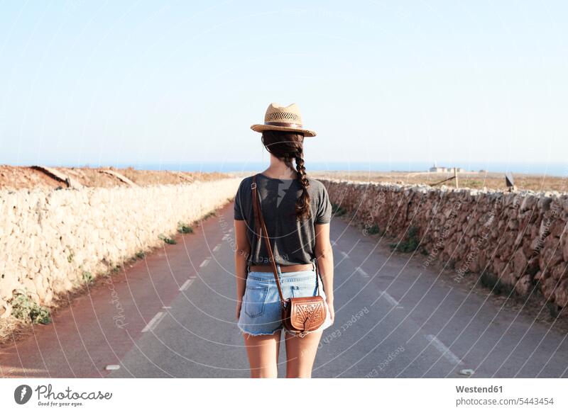 Spanien, Menorca, Rückenansicht eines Alleinreisenden auf der Kreisstraße Landstraße Landstraßen Frau weiblich Frauen Straße Strassen Straßen Erwachsener