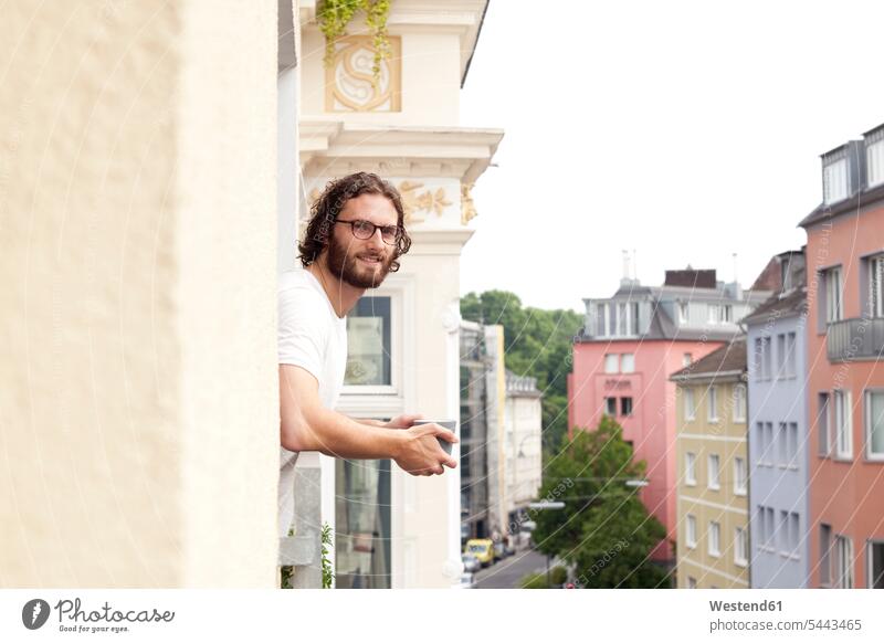 Porträt eines lächelnden Mannes mit Kaffeetasse auf dem Balkon Männer männlich Portrait Porträts Portraits Balkone Erwachsener erwachsen Mensch Menschen Leute