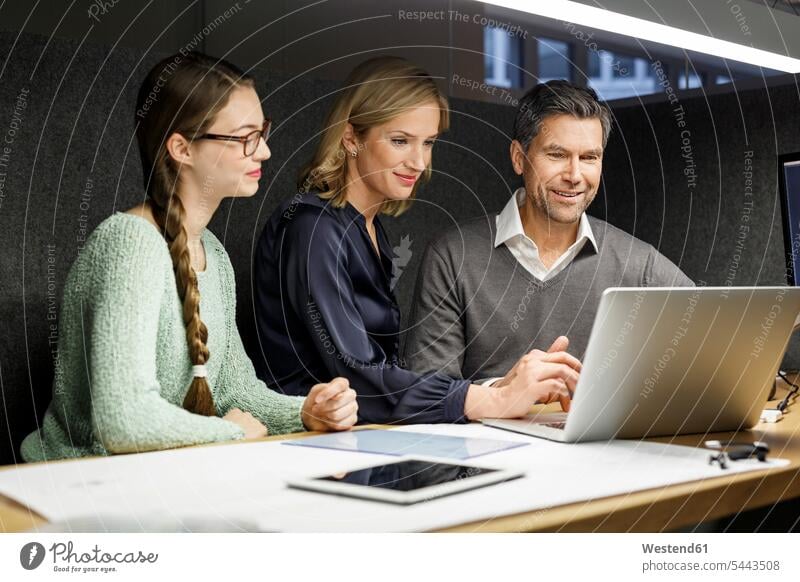 Kollegen, die sich den Laptop in der Besprechungsbox teilen Notebook Laptops Notebooks Arbeitskollegen lächeln Geschäftsleute Geschäftspersonen Büro Office
