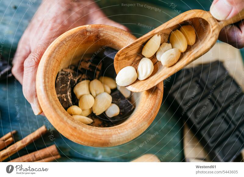 Männerhände gießen Mandeln in eine Holzschüssel mit Schokolade Mann männlich Schokoladen Hand Hände Erwachsener erwachsen Mensch Menschen Leute People Personen
