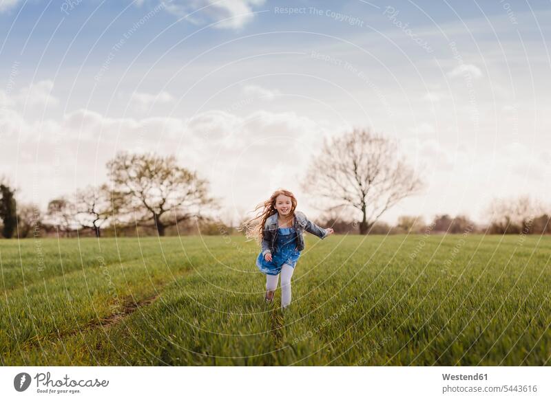 Lächelndes Mädchen rennt auf einem Feld weiblich Felder Kind Kinder Kids Mensch Menschen Leute People Personen schnell Schnelligkeit geschwind Europäer