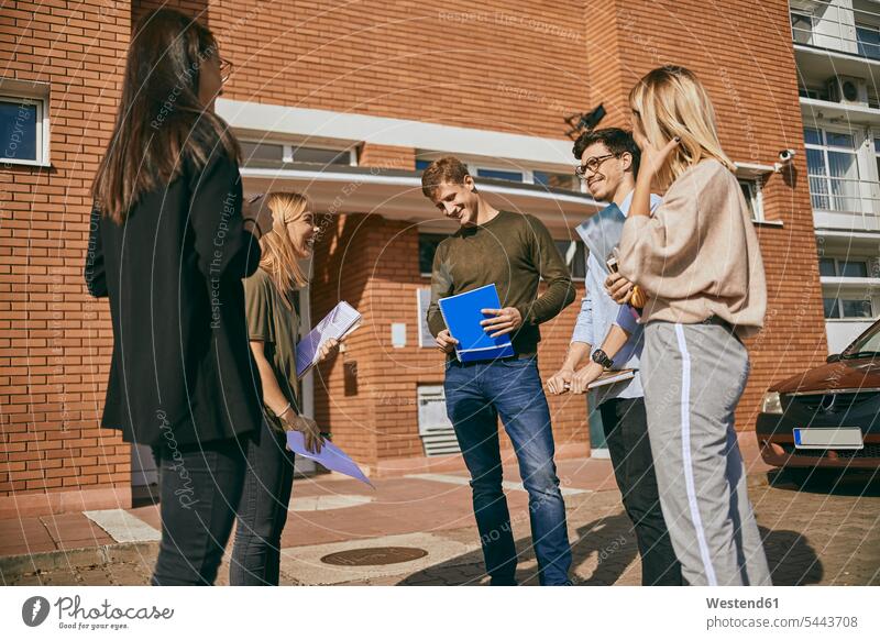 Gruppe glücklicher Studenten, die mit Dokumenten im Freien stehen Unterlagen Gruppe von Menschen Menschengruppe Hochschueler Studierender Hochschüler stehend