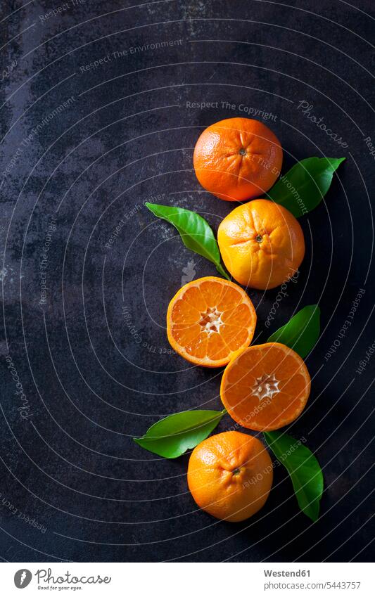 Geschnittene Mandarinen auf dunklem Hintergrund orange Textfreiraum Erhöhte Ansicht Erhöhte Ansichten Gesunde Ernährung Ernaehrung Gesunde Ernaehrung Gesundheit