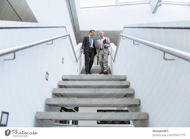 Zwei Geschäftsleute bei einem informellen Treffen Geschäftsmann Businessmann Businessmänner Geschäftsmänner Treppe Treppenaufgang gehen gehend geht Gemeinsam