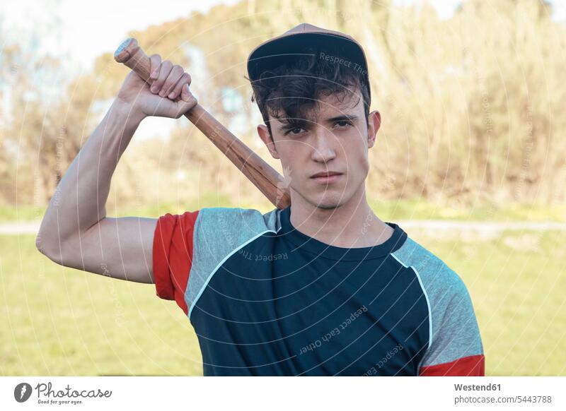 Porträt eines jungen Mannes mit Baseballschläger im Park Männer männlich Schläger Baseballspiel Baseballspieler Baseballer Erwachsener erwachsen Mensch Menschen