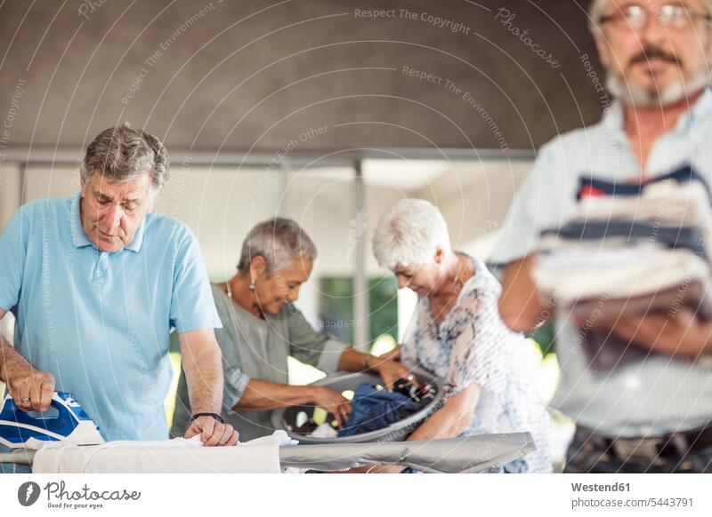 Senioren bügeln gemeinsam Kleidung Freunde Freundschaft Kameradschaft Haushalt lächeln Gemeinsam Zusammen Miteinander ältere Männer älterer Mann Wäsche männlich