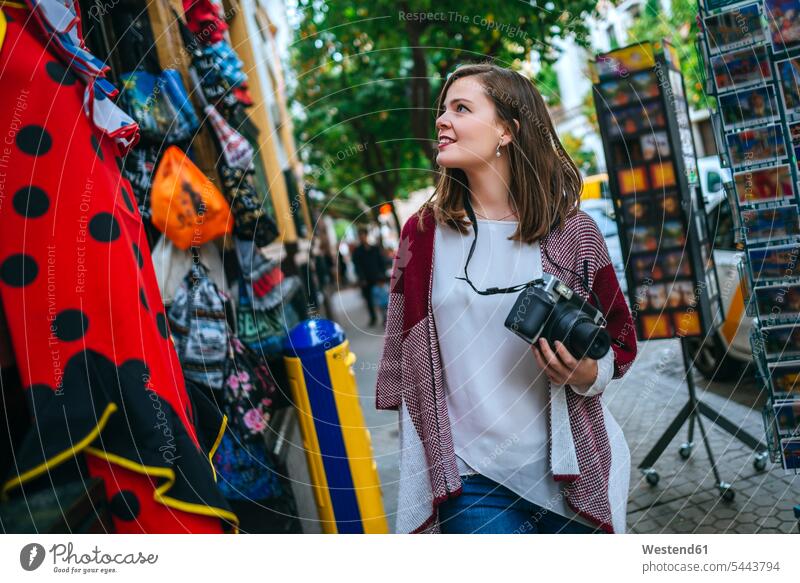 Junge Frau in Sevilla sieht sich Geschäfte an Europäer Kaukasier Europäisch kaukasisch betrachten betrachtend Shopping einkaufen shoppen Einkauf Fotoapparat