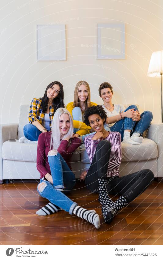 Porträt einer Gruppe von Freundinnen im Wohnzimmer Portrait Porträts Portraits sitzen sitzend sitzt lächeln Zuhause zu Hause daheim Frau weiblich Frauen