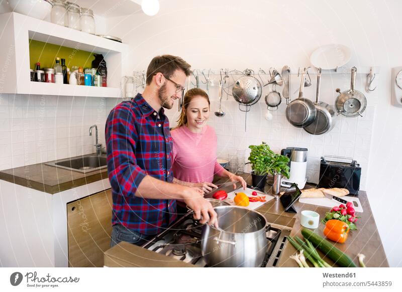 Glückliches junges Paar mit gemeinsam kochender Tablette in der Küche Tablet Computer Tablet-PC Tablet PC iPad Tablet-Computer glücklich glücklich sein
