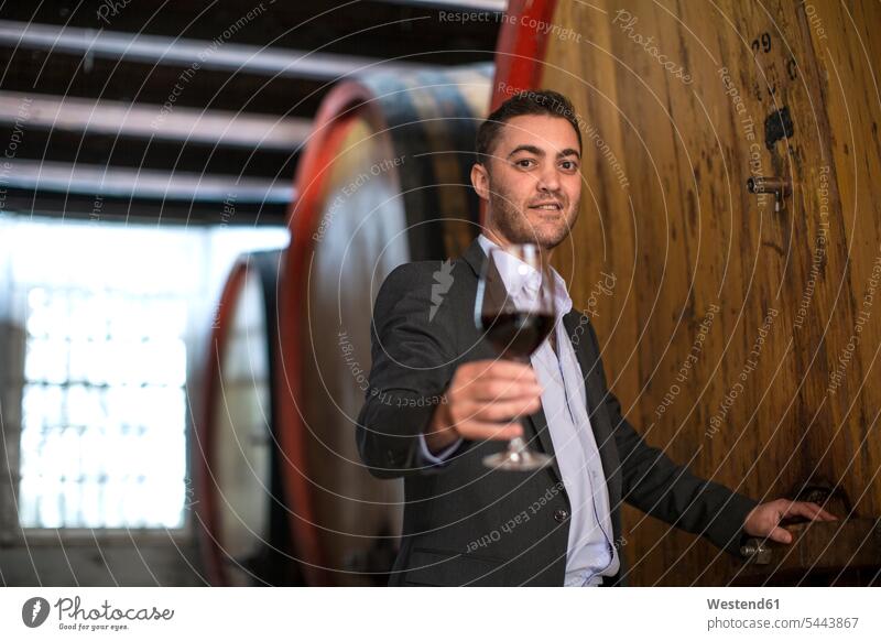 Junger Mann testet Rotwein auf Weingut Mann mittleren Alters Männer mittleren Alters Weingüter Weingueter probieren Weinprobe Weinproben Rotweine männlich