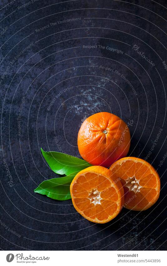 Geschnittene Mandarinen auf dunklem Hintergrund Textfreiraum Erhöhte Ansicht Erhöhte Ansichten Gesunde Ernährung Ernaehrung Gesunde Ernaehrung Gesundheit gesund