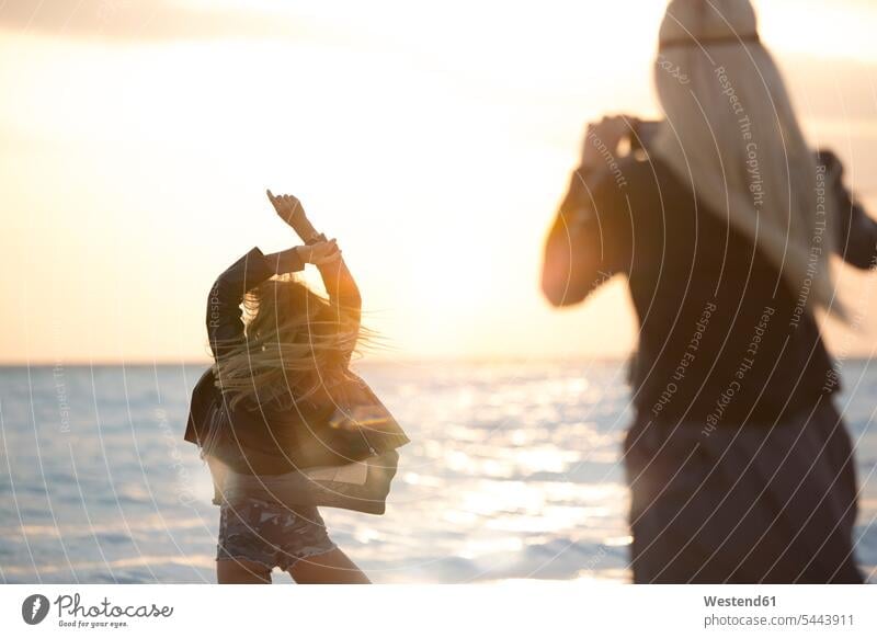 Freunde fotografieren am Strand bei Sonnenuntergang glücklich Glück glücklich sein glücklichsein tanzen tanzend romantisch schwärmerisch schwaermerisch