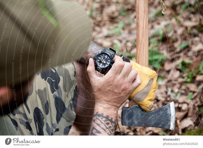 Nahaufnahme eines Mannes mit Axt im Wald bei der Zeitkontrolle Forst Wälder Armbanduhr Armbanduhren Beil Tattoo Tätowierungen Tatoos Taetowierung Tattoos