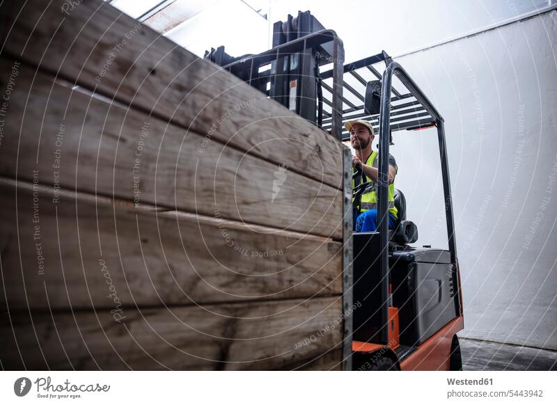 Mann auf Gabelstapler im Lager Lagerhalle Lagerhallen Arbeiter arbeiten Depot Job Kraftfahrzeug Verkehrsmittel KFZ Kiste Holzkiste Steige Holzverschlag