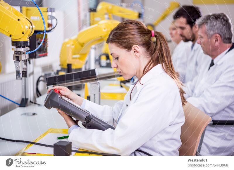 Ingenieure, die Industrieroboter untersuchen Fabrik Fabriken Roboter Technik Techniken Technologie industriell Gewerbe Industrien Ingenieurin Ingenieurinnen