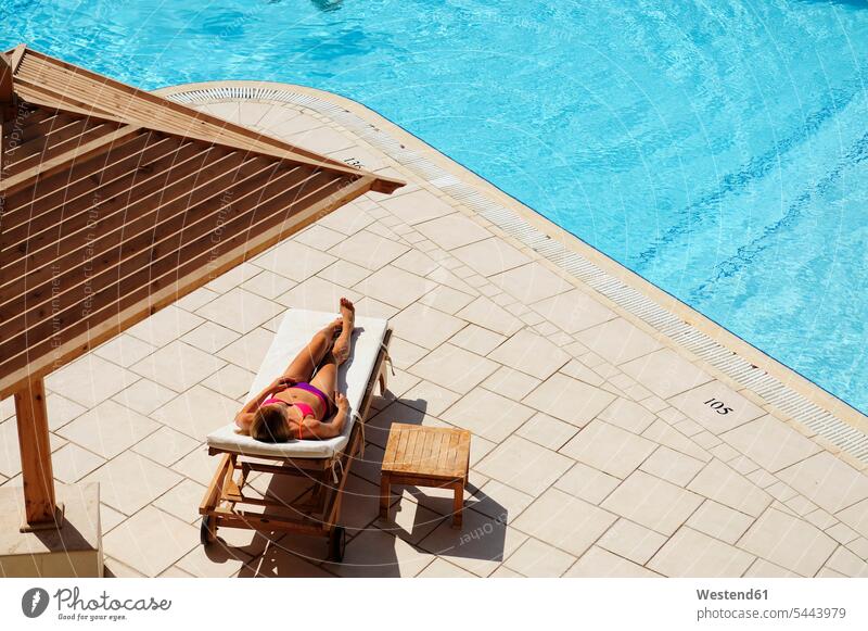 Frau entspannt sich im Liegestuhl am Pool Liegestühle weiblich Frauen entspanntheit relaxt Swimmingpool Swimmingpools Schwimmbecken Swimming Pool Swimming Pools