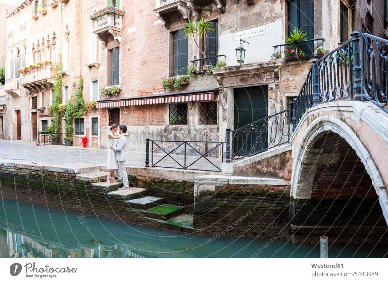 Italien, Venedig, Brautpaar steht sich Auge in Auge auf einer Treppe in der Nähe des Kanals gegenüber Paar Pärchen Paare Partnerschaft Mensch Menschen Leute
