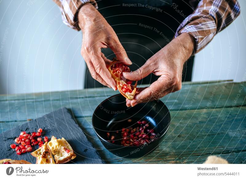 Männerhände schälen einen Granatapfel Granatäpfel Granataepfel Mann männlich Hand Hände Tropische Frucht Tropische Früchte Tropische Fruechte Obst Essen Food