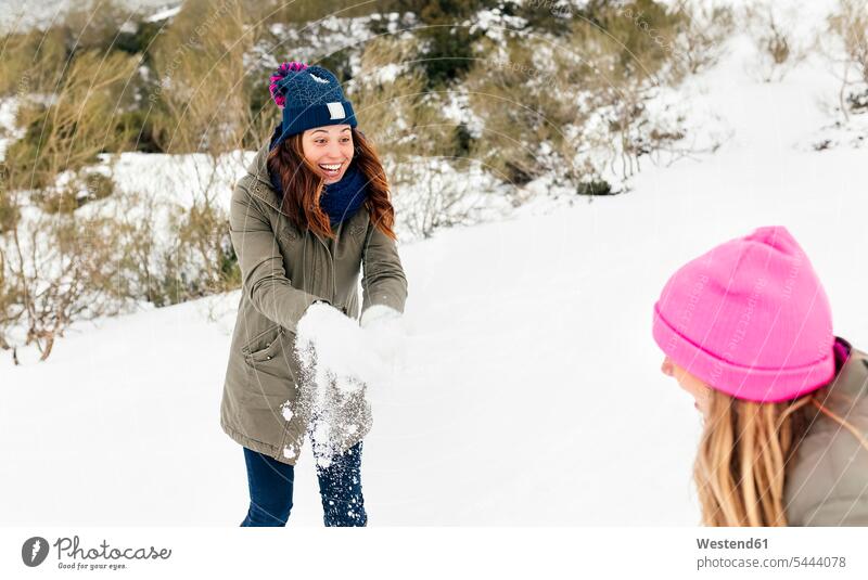 Zwei Freunde amüsieren sich im Schnee Freundschaft Kameradschaft lachen werfen Wurf Freundinnen spielen Winter winterlich Winterzeit Wetter positiv Emotion