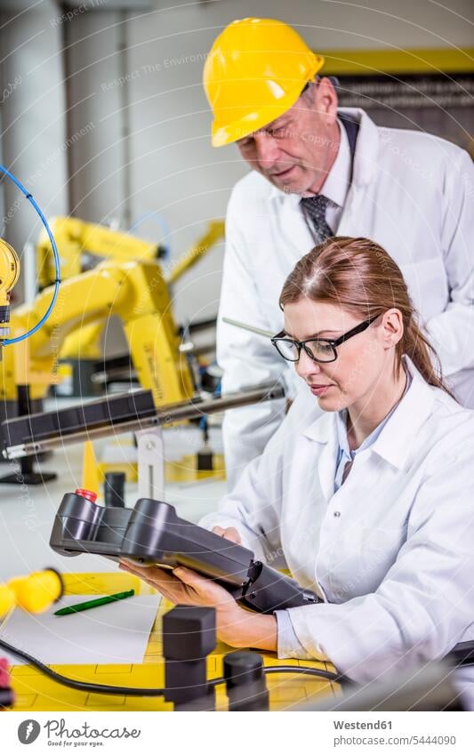 Zwei Ingenieure in der Fabrik sehen sich das Gerät an Fabriken Roboter Technik Techniken Technologie Industrie industriell Gewerbe Industrien Gemeinsam Zusammen