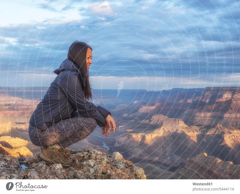 USA, Arizona, Grand Canyon National Park, Touristen, die die Aussicht genießen Fels Felsen Landschaft Landschaften hocken kauernd hockend Himmel Reise Travel