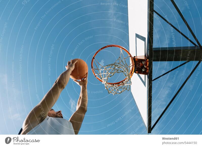 Mann spielt Basketball Basketbaelle Basketbälle Freizeit Muße Männer männlich Basketballspieler Basketballer Sport springen hüpfen werfen Wurf Erwachsener